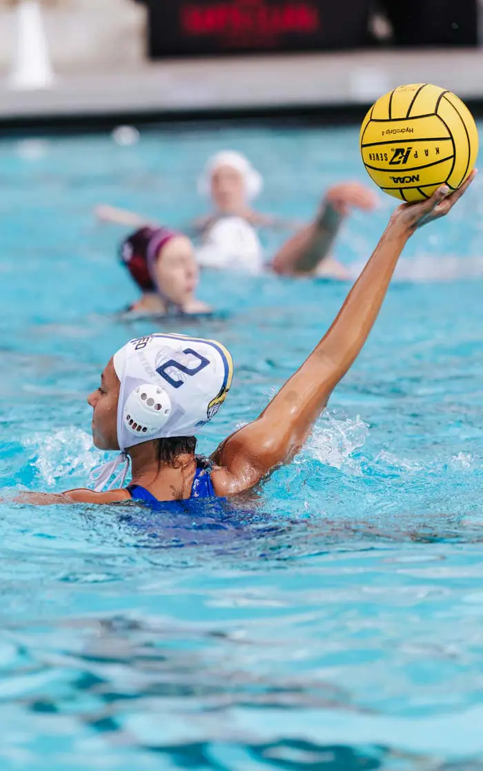 water polo athlete holding ball in the air